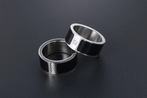 Detail of titanium steel couple rings with black enamel finish and diamond inlay