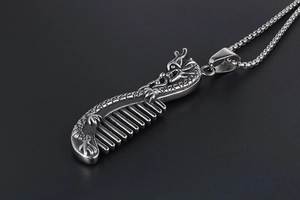 Macro detail of dragon comb pendant in silver titanium steel with intricate textures