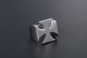 Macro shot of silver chrome cross ring with polished finish and industrial vintage style