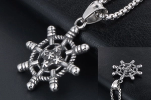 Détail macro du pendentif gouvernail rétro avec finition argent vieilli et centre étoilé