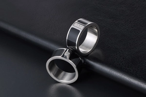 Macro shot of titanium steel couple rings with black enamel and diamond-set details