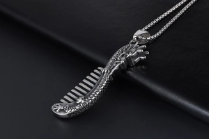 Macro detail of Chinese dragon pattern on a vintage stainless steel comb pendant