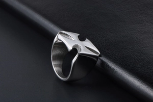 Macro shot of silver metal ring featuring an engraved cross design on a black leather base