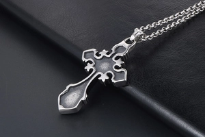 Macro view of vintage gothic cross necklace with silver edges and dark matte finish