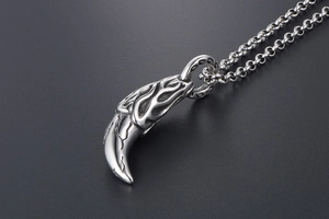 Close-up of wolf tooth pendant with flame patterns and vintage cracked texture metal chain