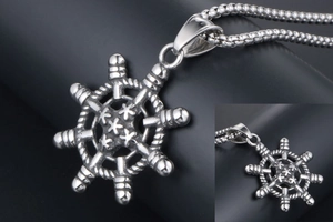 Détail macro du pendentif de gouvernail nautique argenté et de la chaîne à maillons ronds