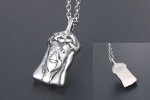 Macro detail of a silver Jesus portrait pendant with crown of thorns and brushed back finish