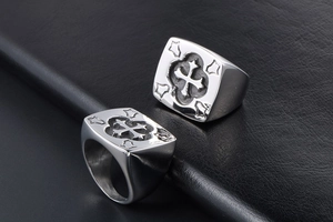 Detailed view of silver cross rings for men with vintage engravings on black leather