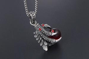 Detail of gothic dragon claw pendant with red gemstone and box chain necklace
