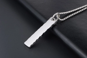 Macro shot of polished stainless steel rectangular pendant with hammered side textures