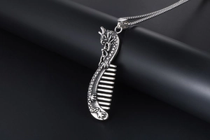 Detailed view of vintage silver dragon engraved comb pendant with rustic metal bead chain