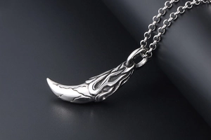 Macro view of vintage wolf tooth pendant with detailed flame and cracked texture