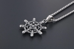 Vue latérale macro du pendentif de gouvernail en acier rétro avec chaîne box
