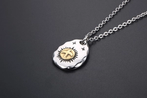 Macro view of vintage eagle pendant with hammered texture and golden sun motif