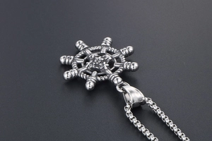 Vue macro d'un pendentif gouvernail vintage avec détails sur chaîne vénitienne