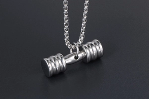 Vue macro d'un pendentif haltère argenté avec une finition en acier inoxydable poli