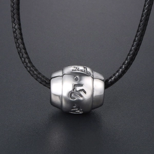 Titanium steel mantra barrel pendant on black woven cord over a textured grey background
