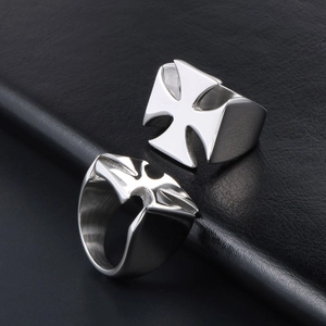 Polished silver stainless steel rings with iron cross and bat logo on leather background