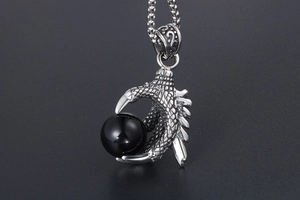 Detailed close-up of a rugged metal dragon claw pendant holding a polished black bead