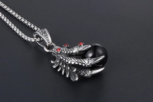 Macro view of dragon claw pendant holding a black bead with red rhinestone details