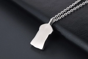 Macro shot of vintage titanium steel necklace pendant featuring a brushed metal bearded profile