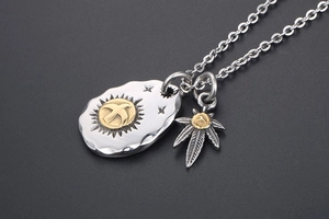 Macro view of retro eagle pendant and leaf charm on a titanium steel necklace