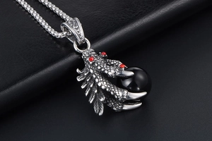 Macro detail of punk dragon claw pendant with black bead and red rhinestone accent