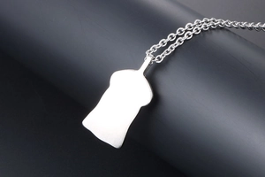Macro shot of silver titanium steel necklace featuring a vintage punk male bust pendant