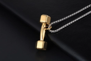 Détail d'un pendentif haltère doré poli sur une chaîne box argentée sur cuir noir