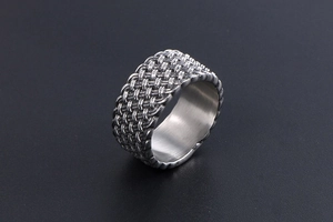 Macro view of woven mesh texture on a vintage stainless steel ring for men