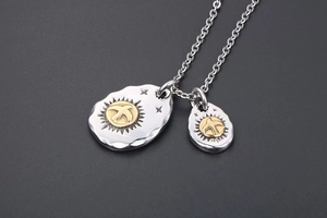 Close-up of eagle pendants with vintage hammered texture and golden sun details