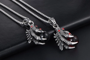Detail of dragon claw pendants with black and red beads on vintage silver chains