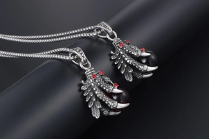 Macro shot of vintage dragon claw pendant with red gemstone on thick metal chain