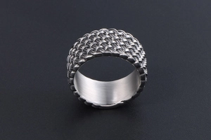 Macro shot of the woven mesh texture and polished inner band of the retro steel ring