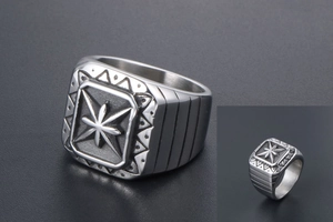 Macro detail of men's vintage signet ring with engraved star pattern and matte silver finish