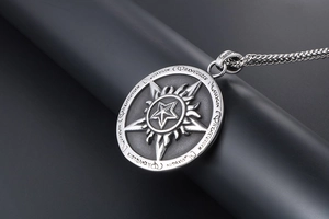 Macro shot of vintage star and sun flame relief on a round stainless steel pendant