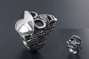 Macro detail of retro skull ring in punk rock style with cigar and hat in steel finish