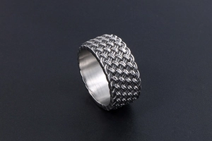 Macro shot of retro braided titanium steel ring with intricate metallic weave texture