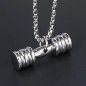 Pendentif haltère en acier inoxydable argenté pour fitness sur une surface sombre