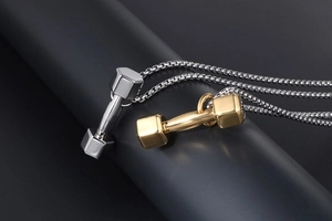 Vue détaillée de pendentifs haltères polis en argent et or sur une chaîne gourmette