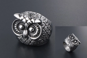 Macro close-up of a vintage owl head ring with antique silver finish and feather details