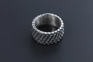 Macro detail of vintage woven texture on wide titanium steel ring for men