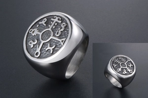 Macro shot of silver signet ring with engraved mystic rune symbol and hammered texture