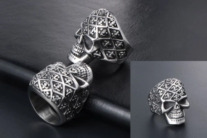 Detail of vintage silver skull ring with fleur-de-lis engraving and diamond texture