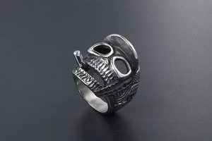 Macro detail of gothic skull ring with hat and cigarette in vintage steel finish