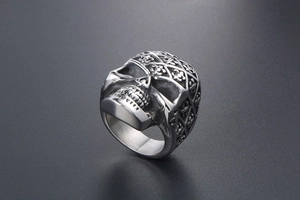 Detailed view of stainless steel skull ring with intricate grid patterns and cross carvings