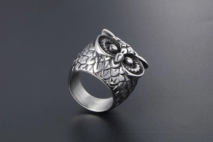 Macro detail of gothic owl ring showing intricate silver feather textures and 3D carving