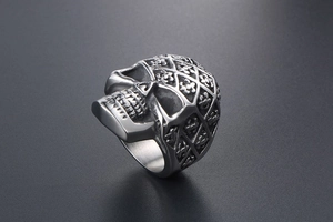 Macro detail of silver skull ring with lattice pattern and engraved cross flower motifs