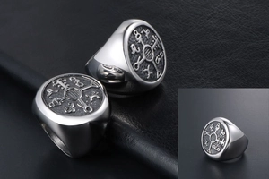 Close-up of vintage titanium steel signet ring with Nordic runes on black leather