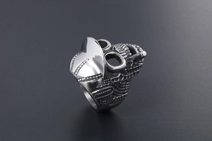 Macro shot of retro stainless steel skull ring wearing a hat and smoking a cigarette